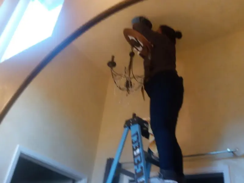 Electrician installing a chandelier in a Hayward residence